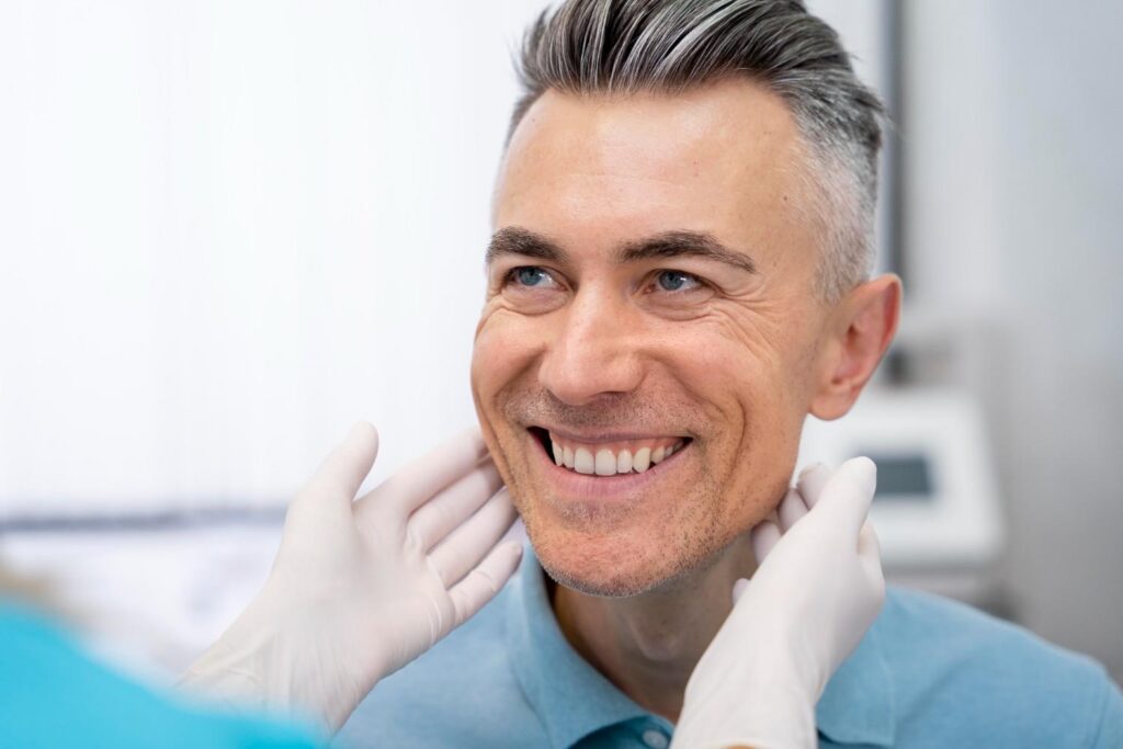 Smiling man during dental checkup showing white teeth