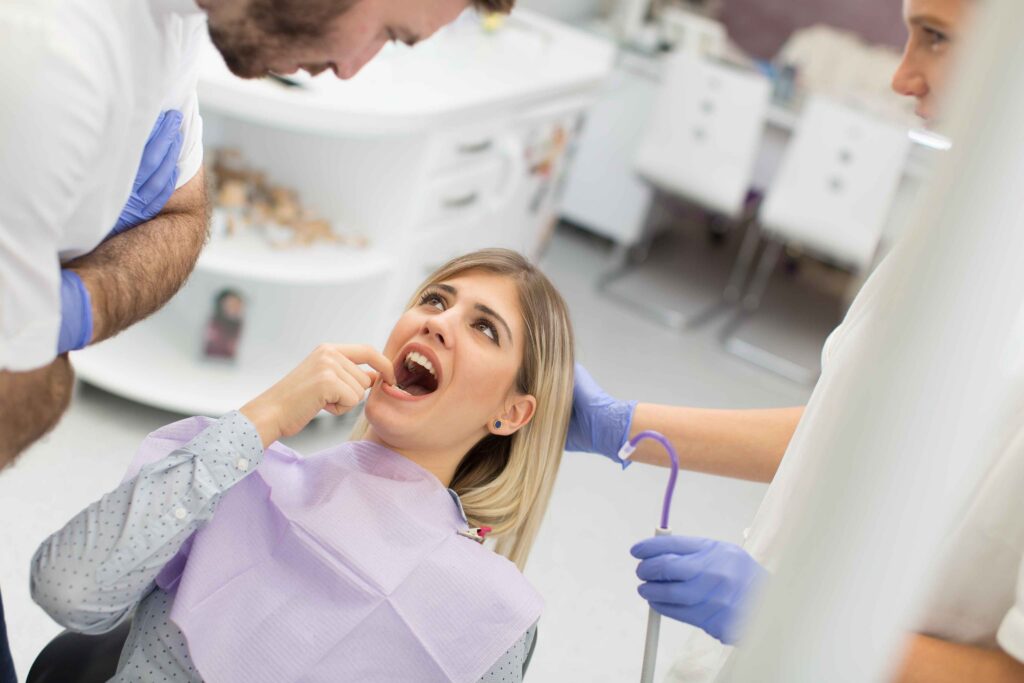 Patient pointing to a tooth during dental exam