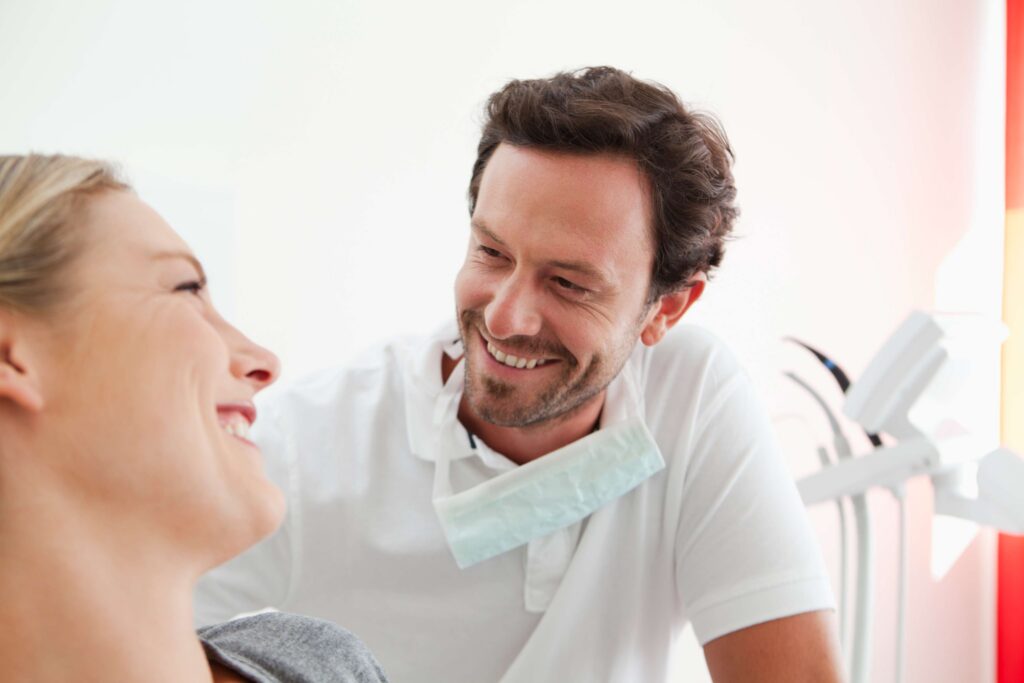 Smiling dentist talking with a happy patient.